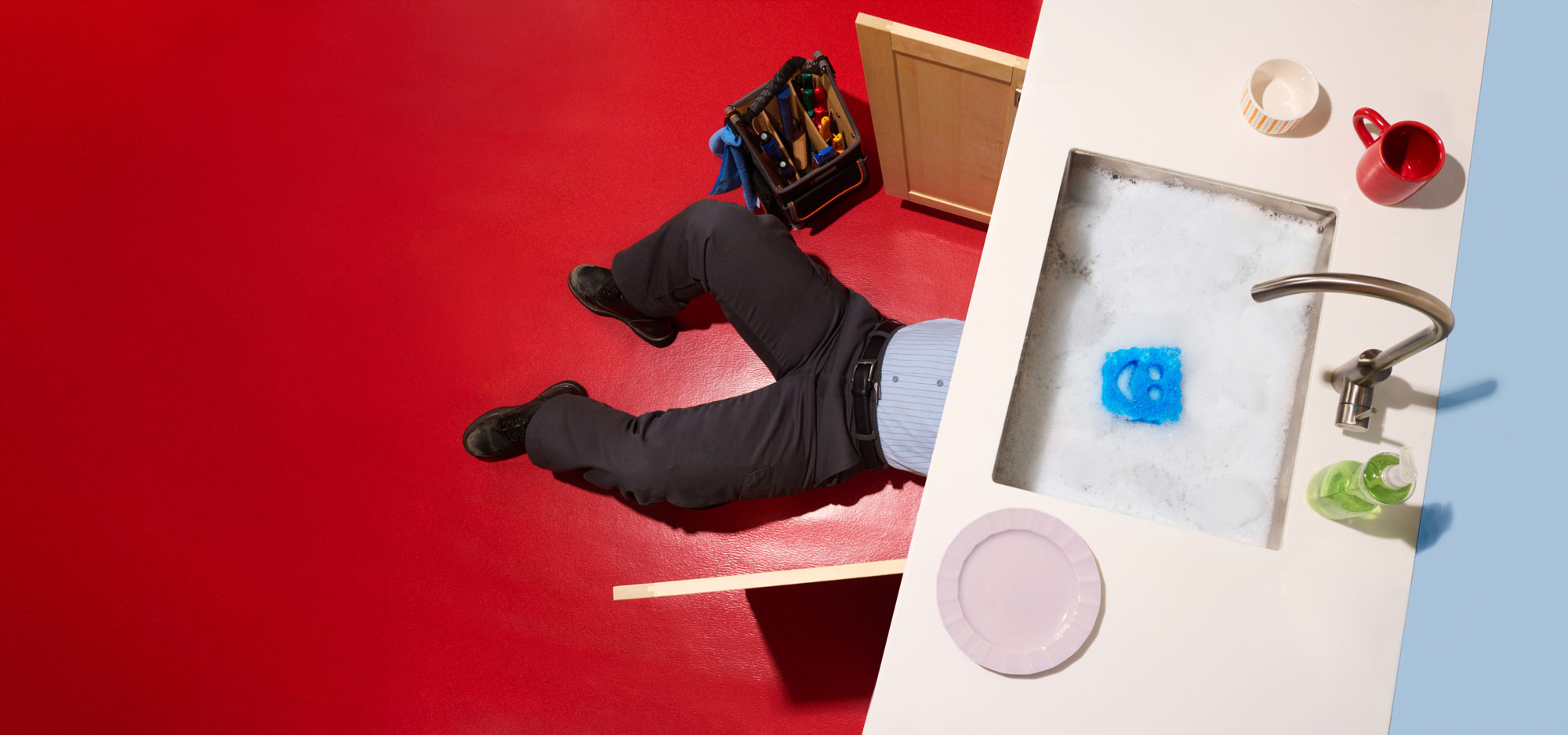 Contractor under a sink fixing a clog.